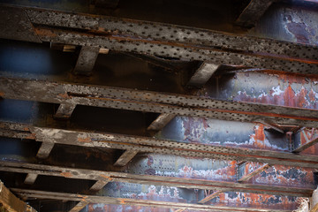 old grungy metal joists under a highway