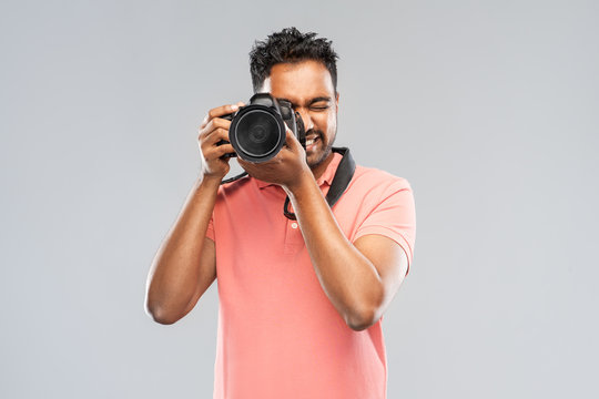 photography, profession and people and concept - happy indian man or photographer with digital camera over grey background