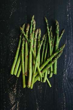 Bunch of fresh cut garden asparagus on a dark rustic wooden table