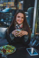 pretty woman at outdoors cafe eating salad