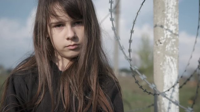 Sadly kid look. Homeless teenager girl sadly looks at the camera.