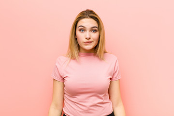 young pretty blonde woman feeling clueless, confused and uncertain about which option to pick,...