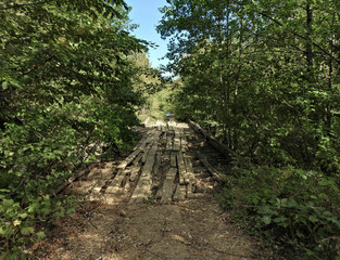 old wooden bridge over a mountain stream on a forest road