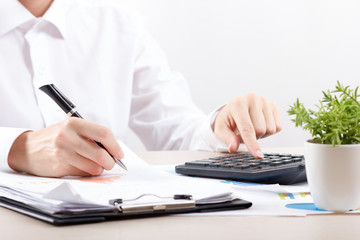 Close up of female accountant or banker making calculations. Savings, finances and economy concept