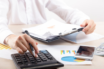 Close up of female accountant or banker making calculations. Savings, finances and economy concept