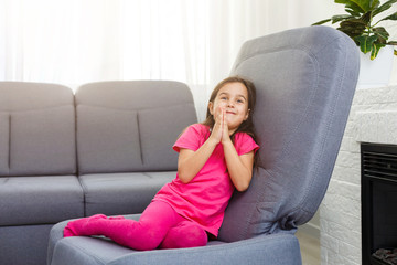 Cute little girl praying at home