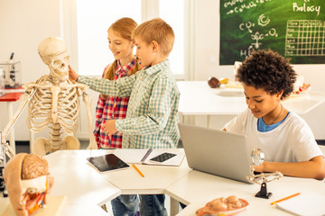 Attentive brunette boy sitting at his computer