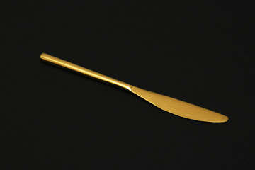 Shiny elegant gold knife on black background