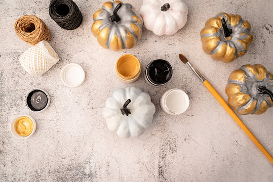 halloween colored pumpkins with paints and a brush top view flat lay