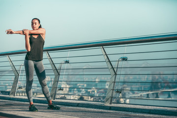 Sportswoman warming arm muscles before running stock photo