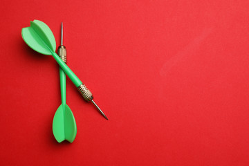 Green dart arrows on red background, flat lay with space for text