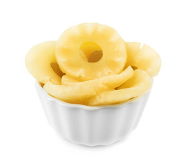 Bowl with slices of delicious sweet canned pineapple on white background