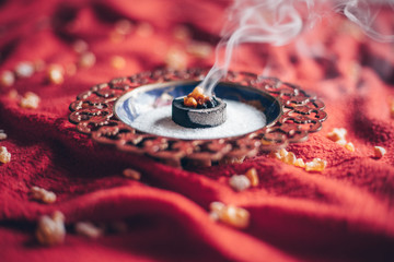 Frankincense burning on a hot coal. Frankincense is an aromatic resin, used for religious rites,...