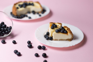 Plate with two pieces of delicious cheesecake. Pink background.