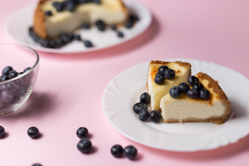 Plate with two pieces of delicious cheesecake. Pink background.