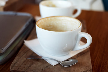 Empty cappuccino cup on a wooden table.