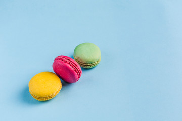 Multicolored macaroons on a blue background, top view, Flatley with copy space