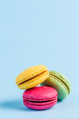 Colorful macaroons on a blue background, close-up, Flatley with copy space