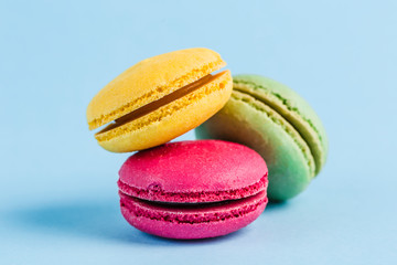 Colorful macaroons on a blue background, close-up, Flatley with copy space