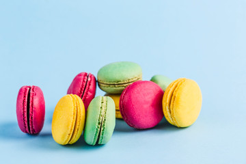 Colorful macaroons on a blue background, close-up, Flatley with copy space