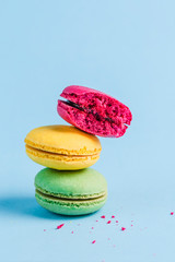 Colorful macaroons on a blue background, close-up, Flatley with copy space