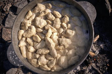 Fresh homemade dumplings in a cauldron close up.
