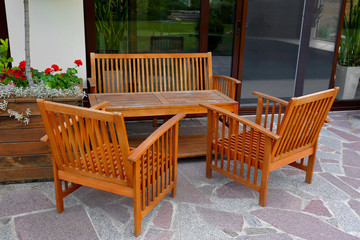 Wooden garden furniture on backyard near modern house