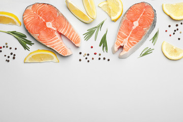 Flat lay composition with salmon steaks on white background. Space for text