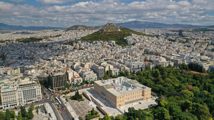 Fototapeta na wymiar Aerial photo of famous Greek Parliament building in Syntagma square and Lycabettus hill at the background with beautiful clouds and deep blue sky, Athens, Attica, Greece