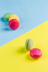Multicolored macaroons on a blue and yellow background, top view, Flatley with copy space