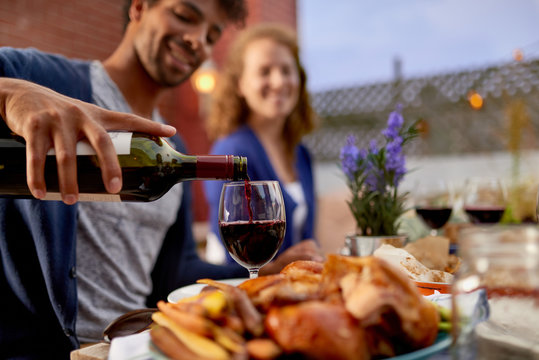 Diverse Couple Having Dinner And A Glass Of Wine Al Fresco In Urban Setting