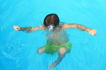 Little child in outdoor swimming pool. Dangerous situation