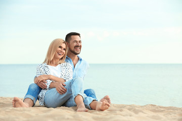 Fototapeta premium Happy romantic couple spending time together on beach, space for text