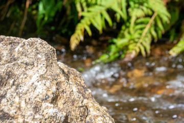 Fototapeta na wymiar Rocks against a clear flowing stream