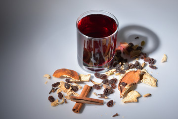 A glass of mulled wine and the ingredients for it