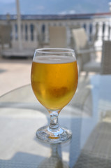 Chilled glass with small drops of condensation on the outside of the glass and filled with golden beer