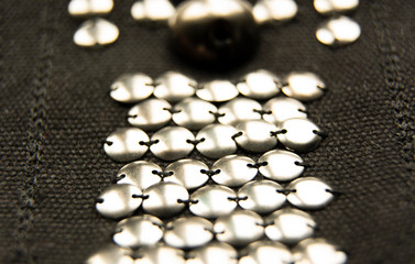 Silver shiny beads and sequins in vintage style are sewn on black coarse fabric.