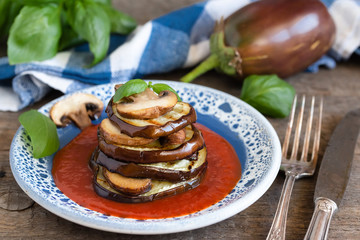 Turrets of grilled eggplants and mushrooms with tomato sauce.