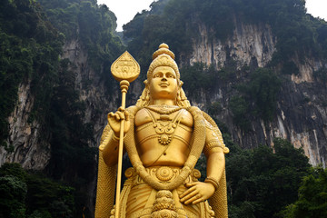 Entrance to Batu Caves with the giant, golden Murugan statue and the 272-step colorful staircase