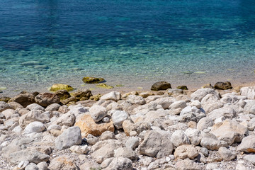 Fototapeta na wymiar Pupnat stone beach and clear blue Adriatic sea water, Korcula, Dalmatia, Croatia, popular touristic place
