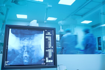Two doctors during neurosurgery with x-ray monitoing