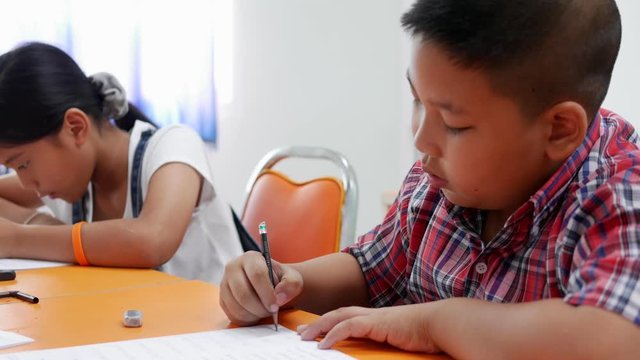 Asian elementary school boy and girl are studying  in the classroom with female teachers.