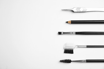 Set of professional eyebrow tools on white background, flat lay. Space for text