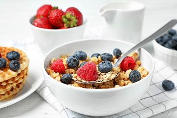 Tasty breakfast with muesli on white wooden table, closeup
