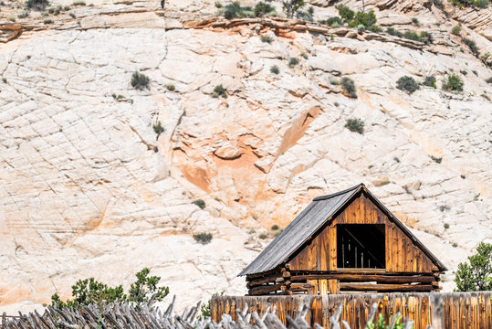 Old vintage wooden farm cabin on road in Grand Staircase Escalante National Monument with canyon formations in Utah summer