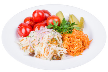 Marinated cucumbers and red tomatoes in a white plate, isolated close-up