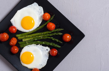 Healthy breakfast with eggs , asparagus and tomatoes