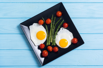 Healthy breakfast with eggs , asparagus and tomatoes