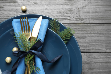 Christmas table setting on grey wooden background, flat lay