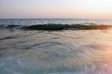 Obraz premium Sunset over the sea. Beautiful sky and sea waves in the rays of the setting sun.
